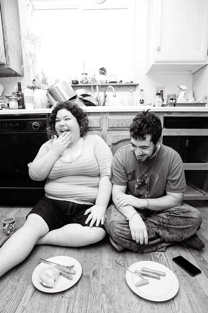 brother and sister sitting on floor watching video and eating