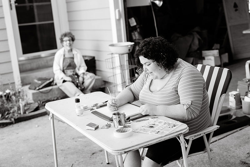 young woman playing game while mother is watching