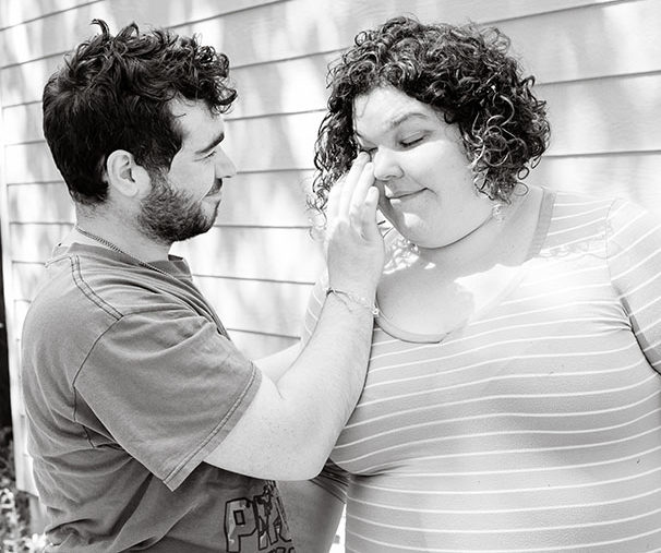 brother wiping tears off sisters face