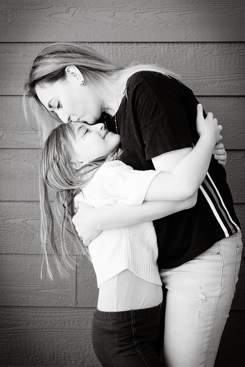 mom kissing daughter on the head