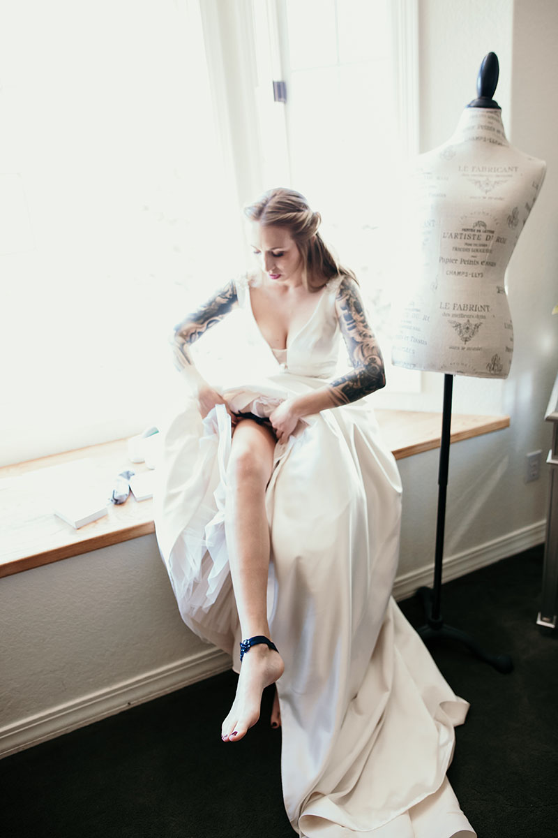 Bride putting on garter at wedding