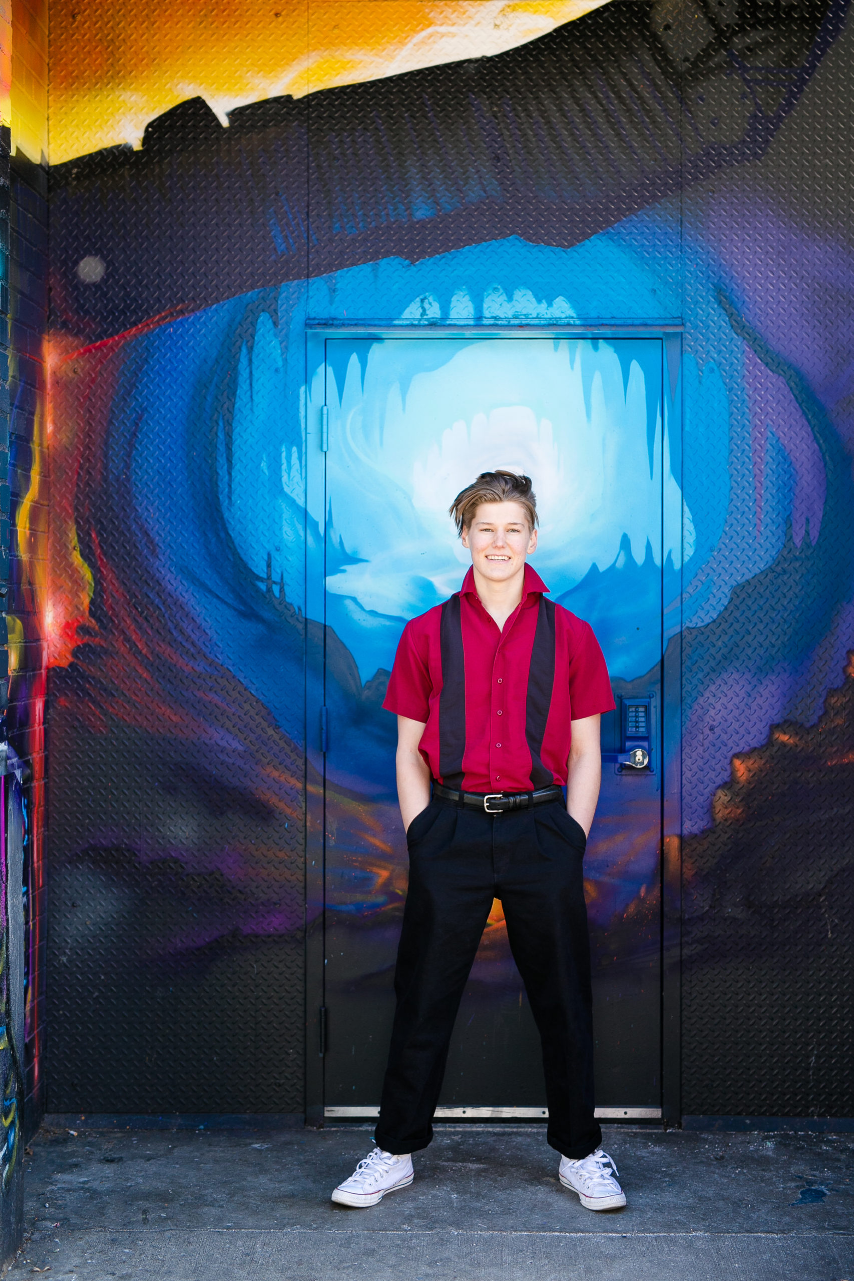 high school senior boy against graffiti wall