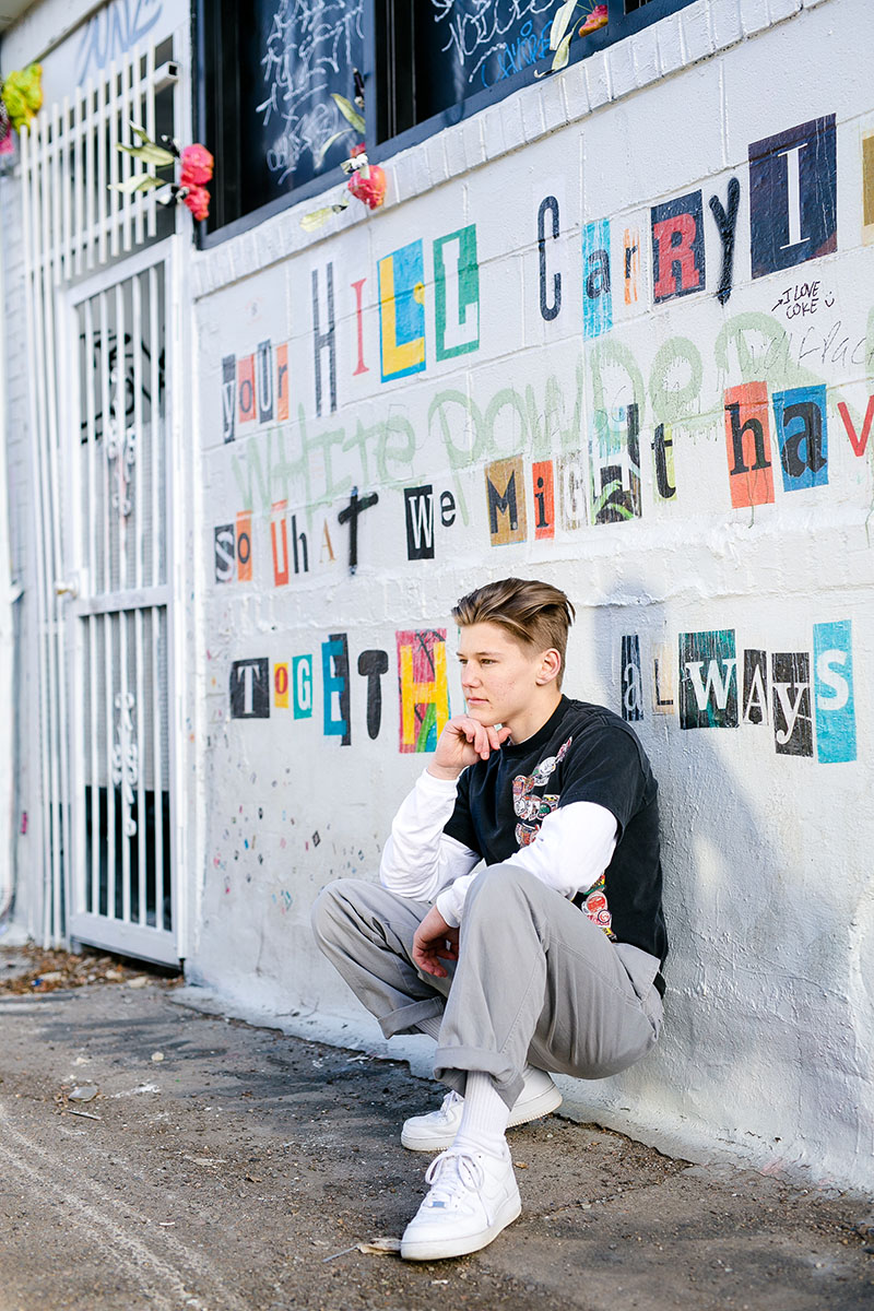 High school senior boy looking away with graffiti background
